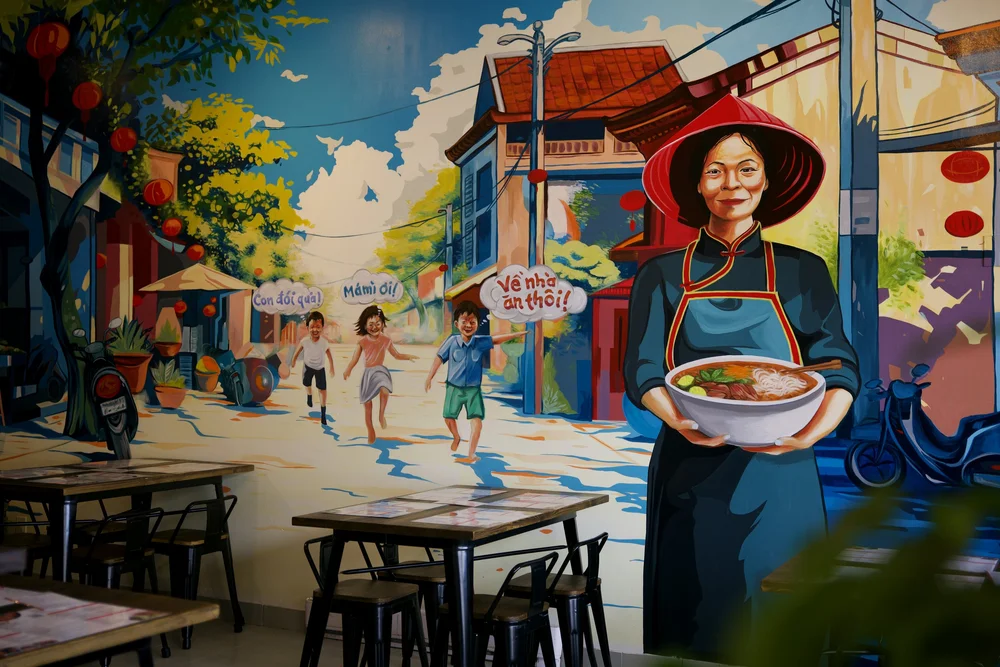 The full Chào Mámì mural — Mámì in a red nón lá holding a bowl of pho on a sunny Vietnamese street